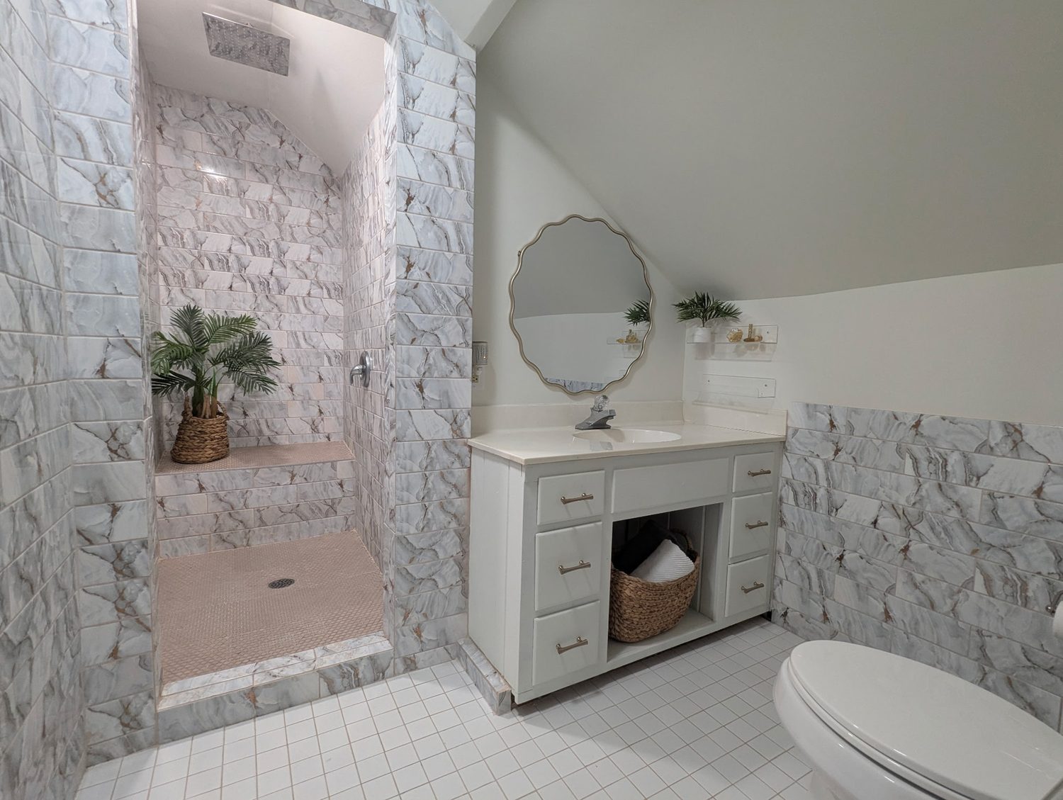 Upper suite full bath with marble-look tile and walk-in shower